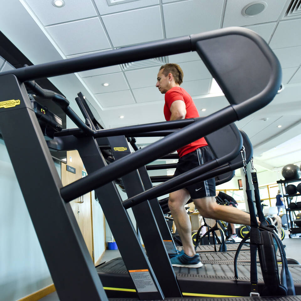 A female health club member running on a treadmill at Castle Royle's gym